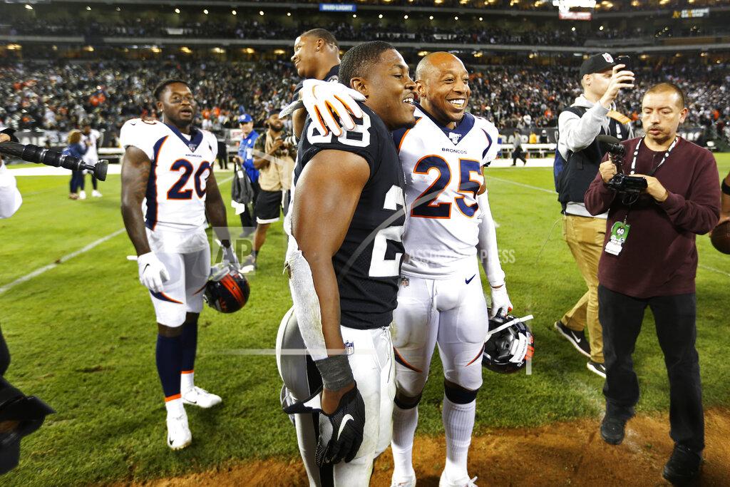 D. Ross Cameron Oakland Raiders running back Josh Jacobs stands with Denver Broncos cornerback Chris Harris (25) at the end of an NFL football game Monday, Sept. 9, 2019, in Oakland, Calif. Oakland won the game 24-16. In the background is Denver Broncos defensive back Duke Dawson (20). (AP Photo/D. Ross Cameron)