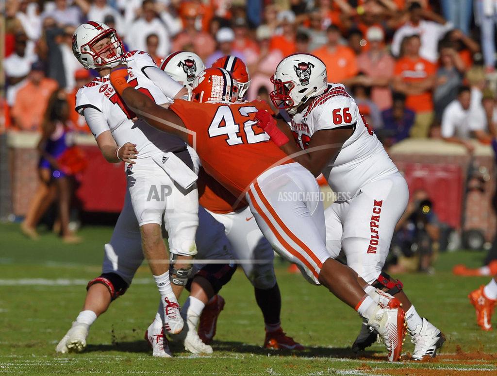 Richard Shiro North Carolina State quarterback Ryan Finley (15) is pressured by Clemson's Christian Wilkins (42) while Joshua Fedd-Jackson (66) tries to block during the first half of an NCAA college football game Saturday, Oct. 20, 2018, in Clemson, S.C. (AP Photo/Richard Shiro)