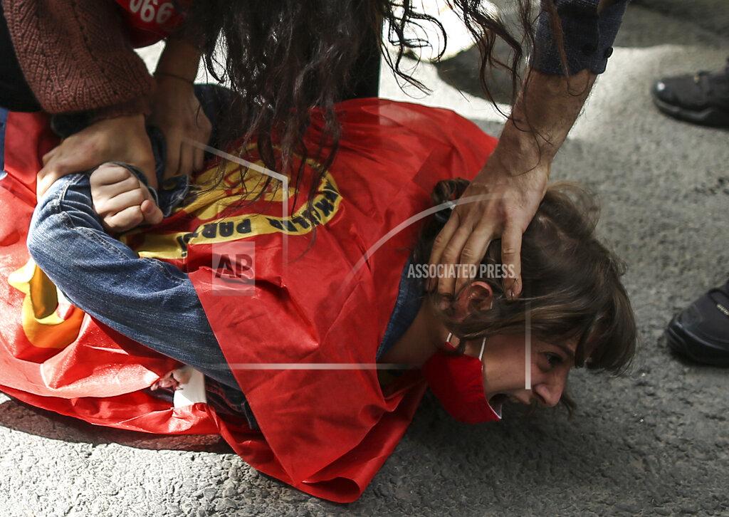 Emrah Gurel A protester reacts as police officers detain her after she and others tried to push through a police barricade towards Taksim Square in central Istanbul during May Day protests, Saturday, May 1, 2021. Police in Istanbul detained several demonstrators who tried to march toward Istanbul's symbolic Taksim Square in defiance of the protests ban and the strict lockdown imposed by the government due to the coronavirus outbreak. (AP Photo/Emrah Gurel)