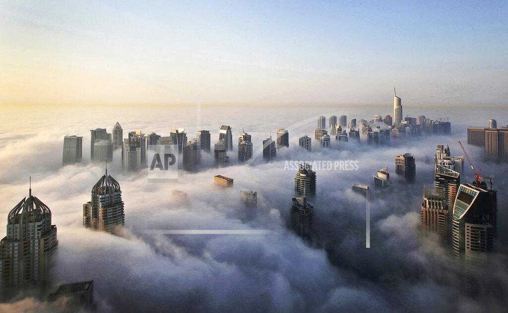 FILE - In Oct. 5, 2015 file photo, a thick blanket of early morning fog partially shrouds the skyscrapers of the Marina and Jumeirah Lake Towers districts of Dubai, United Arab Emirates. Police in Dubai arrested a group of people on charges of public debauchery, authorities said Saturday, April 3, 2021, over a widely shared video that showed naked women posing on a balcony in the Marina. (AP Photo/Kamran Jebreili, File)