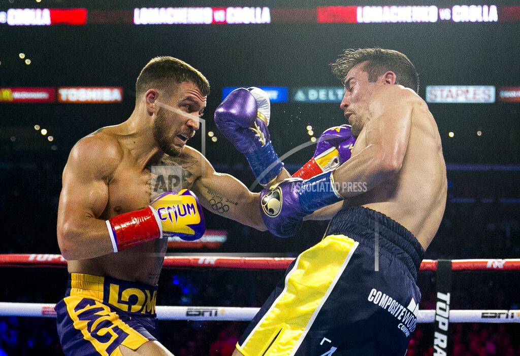 Damian Dovarganes FILE - In this April 12, 2019, file photo, Vasiliy Lomachenko, left, from Ukraine, hits Anthony Crolla, from Britain, during a WBA and WBO lightweight title boxing match in Los Angeles. In ordinary times Vasiliy Lomachenko and Teofimo Lopez would be the fight of the fall, a lightweight title match about as compelling as it gets in the boxing world these days. Instead of a big crowd, the only fans at the MGM Grand conference center will be a few hundred sponsors and first responders with special invites. And, instead of pay-per-view, the fight will be televised live on ESPN, guaranteeing a larger audience than a pay-per-view even if the money isn’t nearly the same. (AP Photo/Damian Dovarganes, File)