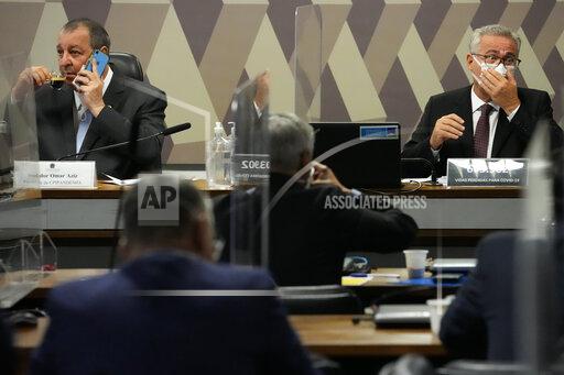 Senators Omar Aziz, left, and Renan Calheiros, attend a session by their commission investigating the government's management of the COVID-19 pandemic at the Federal Senate in Brasilia, Brazil, Wednesday, Oct. 20, 2021. Calheiros formally presented his report recommending President Jair Bolsonaro be indicted on criminal charges for allegedly bungling Brazil's response to pandemic and pushing the country's death toll to second-highest in the world. (AP Photo/Eraldo Peres)