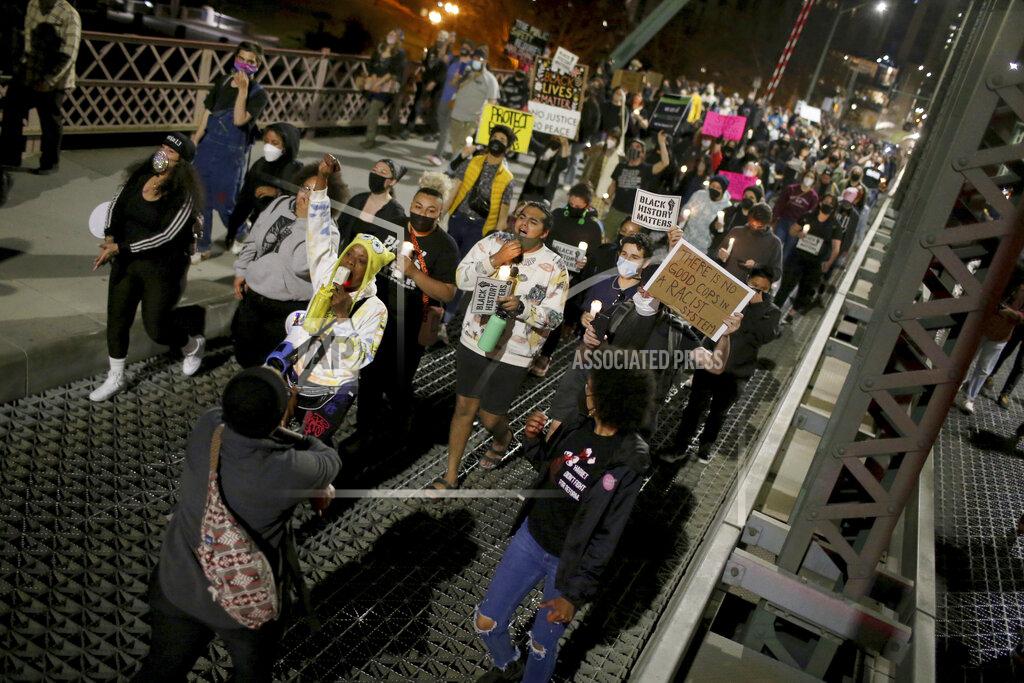 Dave Killen A group marches towards the Hawthorne Bridge after meeting at Salmon Street Springs and listening to several Black and Indigenous speakers talk, Friday, April 16, 2021, in Portland, Ore. Police in Portland, said Saturday they arrested several people after declaring a riot Friday night when protesters smashed windows, burglarized businesses and set multiple fires during demonstrations that started after police fatally shot a man while responding to reports of a person with a gun. (Dave Killen/The Oregonian/The Oregonian via AP)