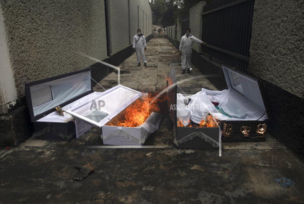 Marco Ugarte FILE - In this June 24, 2020 file photo, crematorium workers burn the coffins that contained the remains of people who died from the coronavirus after their cremation at the San Nicolas Tolentino cemetery in the Iztapalapa neighborhood of Mexico City. As Mexico approaches 200,000 in officially test-confirmed deaths from COVID-19, the real death toll is probably higher due to the country’s extremely low rate of testing. (AP Photo/Marco Ugarte, File)