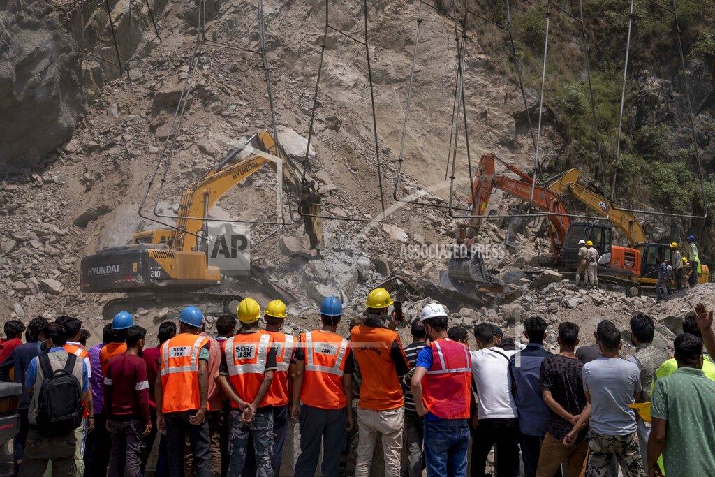 Dar Yasin Rescue workers watch from a distance as earth movers dig through rubble of a collapsed tunnel in Ramban district, south of Srinagar, Indian controlled Kashmir, Friday, May 20, 2022. An official in Indian-controlled Kashmir said Friday that 10 workers were trapped after part of a road tunnel collapsed in the Himalayan region. (AP Photo/Dar Yasin)