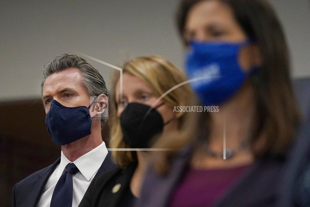 Jeff Chiu Gov. Gavin Newsom, from left, Assemblywoman Buffy Wicks, D-Oakland, and Oakland Mayor Libby Schaaf listen to spekers at a news conference in Oakland, Calif., Monday, July 26, 2021. California will require state employees and all health care workers to show proof of COVID-19 vaccination or get tested weekly. Officials are tightening restrictions in an effort to slow rising coronavirus infections in the nation's most populous state, mostly among the unvaccinated. (AP Photo/Jeff Chiu)