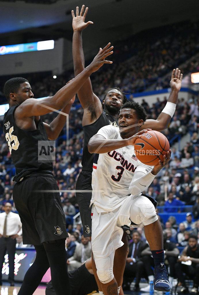 Jessica Hill Connecticut's Alterique Gilbert, looks to pass around the defense of Central Florida's Collin Smith, left, and Central Florida's Chad Brown, back, during the first half of an NCAA college basketball game, Saturday, Jan. 5, 2019, in Hartford, Conn. (AP Photo/Jessica Hill)