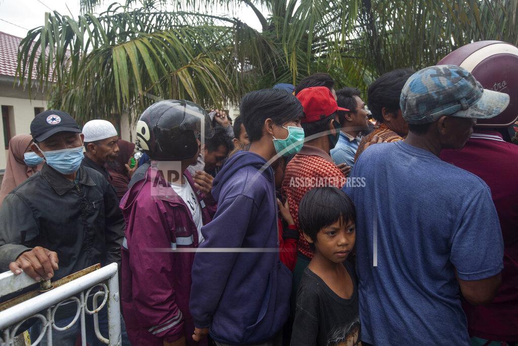 Yusuf Wahil People who are affected by an earthquake queue up for food aid in Mamuju, West Sulawesi, Indonesia, Sunday, Jan. 17, 2021. Rescuers retrieved more bodies from the rubble of homes and buildings toppled by the magnitude 6.2 earthquake while military engineers managed to reopen ruptured roads to clear access for relief goods. (AP Photo/Yusuf Wahil)