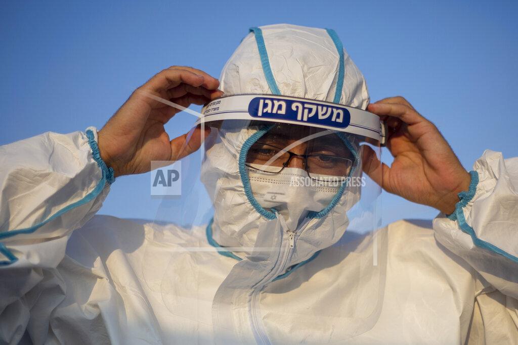 Ariel Schalit A healthcare worker adjusts his protective gear at a drive-thru COVID-19 testing centre set up at a parking area in east Jerusalem neighborhood of Sheikh Jarrah, Thursday, Sept. 10, 2020. Israel this week imposed new restrictions on some 40 cities and towns with worrying outbreaks, which include nighttime curfews, strict limits on public gatherings and the shuttering of schools. (AP Photo/Ariel Schalit)