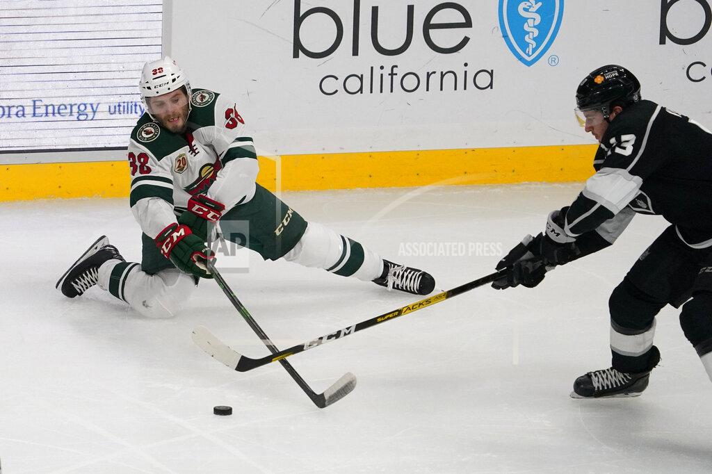 Mark J. Terrill Minnesota Wild left wing Ryan Hartman, left, tries to pass the puck as Los Angeles Kings center Gabriel Vilardi reaches in during the second period of an NHL hockey game Tuesday, Feb. 16, 2021, in Los Angeles. (AP Photo/Mark J. Terrill)
