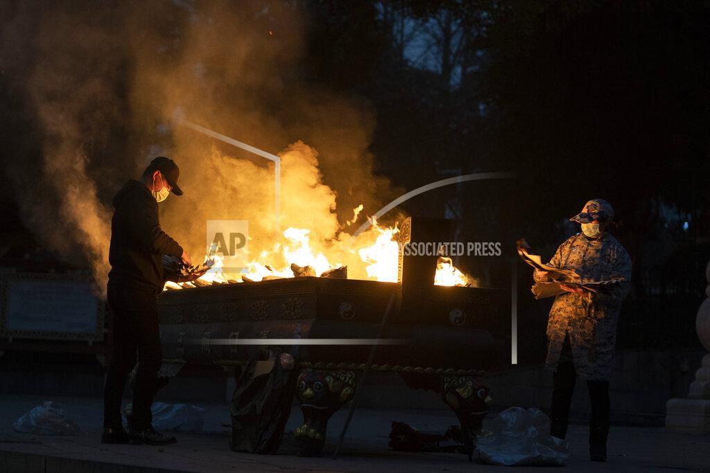 Ng Han Guan Residents burn paper offerings to a relative who died from the coronavirus on the eve of the anniversary of the 76-day lockdown in the central Chinese city where the coronavirus was first detected, in Wuhan in central China's Hubei province Friday, Jan. 22, 2021. (AP Photo/Ng Han Guan)
