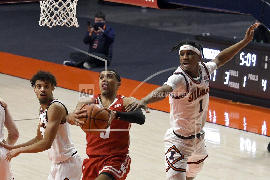 Holly Hart Wisconsin's guard D'Mitrik Trice goes to the basket as Illinois guards Trent Frazier (1) and Jacob Grandison defends in the first half of an NCAA college basketball game Saturday, Feb. 6, 2021, in Champaign, Ill. (AP Photo/Holly Hart)