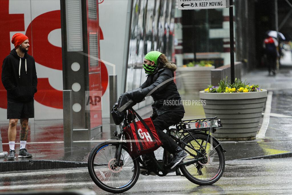 Frank Franklin Ii A delivery person with his face covered during the coronavirus outbreak turns onto Seventh Avenue Friday, April 3, 2020, in New York's Times Square. The new coronavirus causes mild or moderate symptoms for most people, but for some, especially older adults and people with existing health problems, it can cause more severe illness or death. (AP Photo/Frank Franklin II)