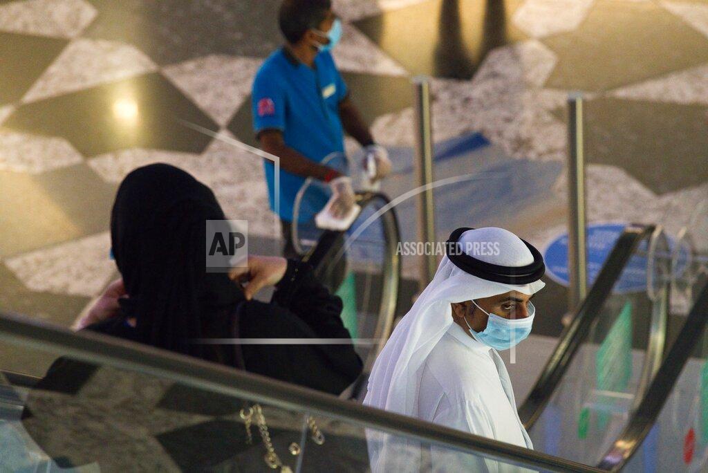 Jon Gambrell An Emirati man and woman ride an escalator at Mall of the Emirates in Dubai, United Arab Emirates, Wednesday, May 27, 2020. Dubai on Wednesday loosed its restrictions imposed over the coronavirus pandemic, allowing movie theaters and other attractions to operate. (AP Photo/Jon Gambrell)