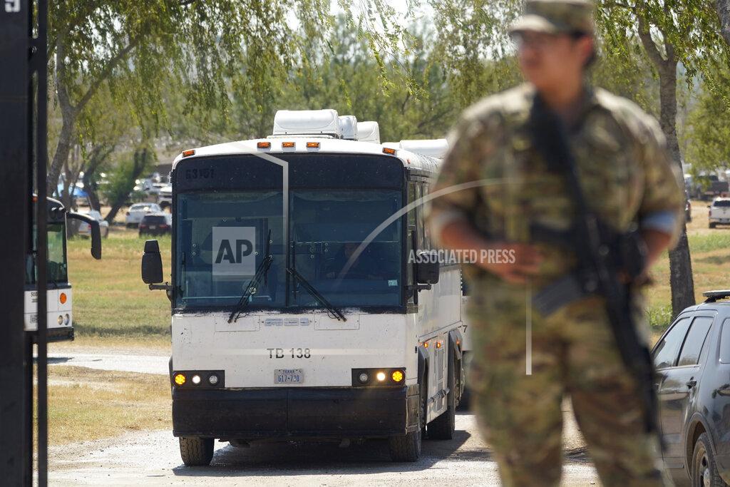 Eric Gay A National Guardsman stands at a gate along a border fence as a bus used to transport migrants, mostly from Haiti, departs from a makeshift camp that has developed at the International Bridge, Monday, Sept. 20, 2021, in Del Rio, Texas. The U.S. is flying Haitians camped at Texas border town back to their homeland and trying to block others from crossing the border from Mexico. (AP Photo/Eric Gay)