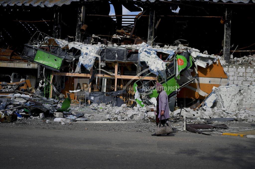 Natacha Pisarenko A woman walks in front of a damage building ruined by attacks in Irpin, outskirts Kyiv, Ukraine, Thursday, May 26, 2022. (AP Photo/Natacha Pisarenko)