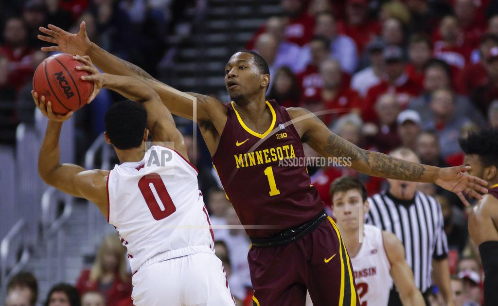Andy Manis Minnesota's Dupree McBrayer (1) reaches for the ball held by Wisconsin's D'Mitrik Trice (0) during the first half of an NCAA college basketball game Thursday, Jan. 3, 2019, in Madison, Wis. (AP Photo/Andy Manis)