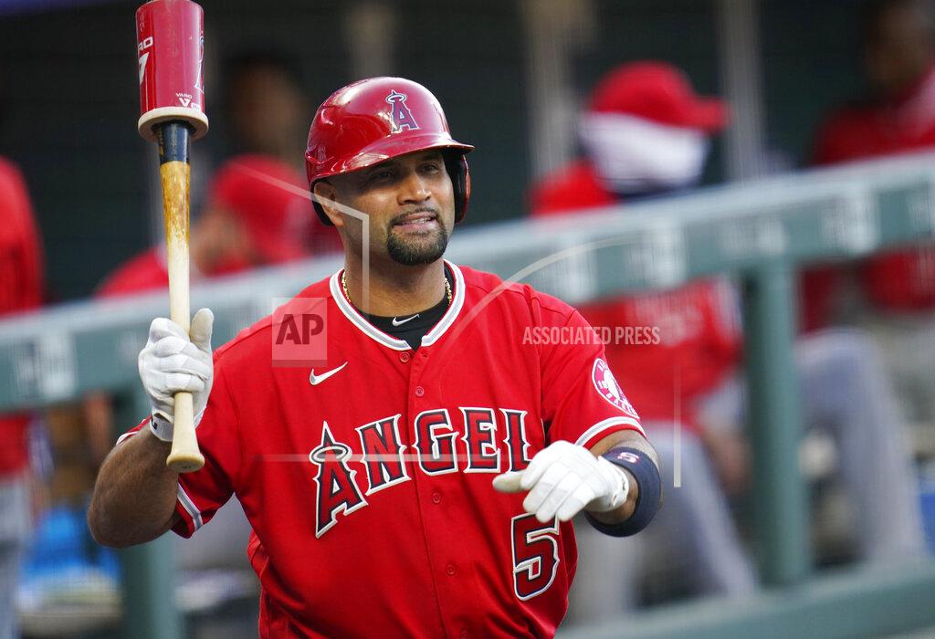 FILE - In this Sept. 12, 2020, file photo, Los Angeles Angels designated hitter Albert Pujols waves to players in the Colorado Rockies dugout in the second inning of a baseball game in Denver. Pujols’ wife apparently disclosed that the Angels slugger will retire after the upcoming season, although she later amended her social media post to be less definitive. (AP Photo/David Zalubowski, File)