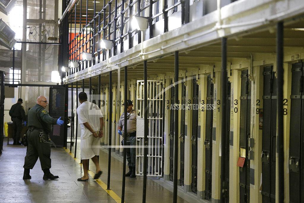 Eric Risberg FILE - In this Aug. 16, 2016 file photo, a condemned inmate is led out of his east block cell on death row at San Quentin State Prison in San Quentin, Calif. The California Labor and Workforce Development Agency confirmed Tuesday, Dec. 1, 2020, that California has sent about $400 million in unemployment benefits to state prison inmates. In all records show 31,000 inmates have applied for benefits and about 20,800 were paid $400 million. A group of local and federal prosecutors said 133 inmates on death row were named in claims. (AP Photo/Eric Risberg, File)