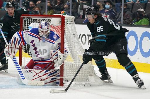 New York Rangers goaltender Igor Shesterkin, left, defends a shot attempt against San Jose Sharks center Jasper Weatherby (26) during the first period of an NHL hockey game in San Jose, Calif., Thursday, Jan. 13, 2022. (AP Photo/Jeff Chiu)