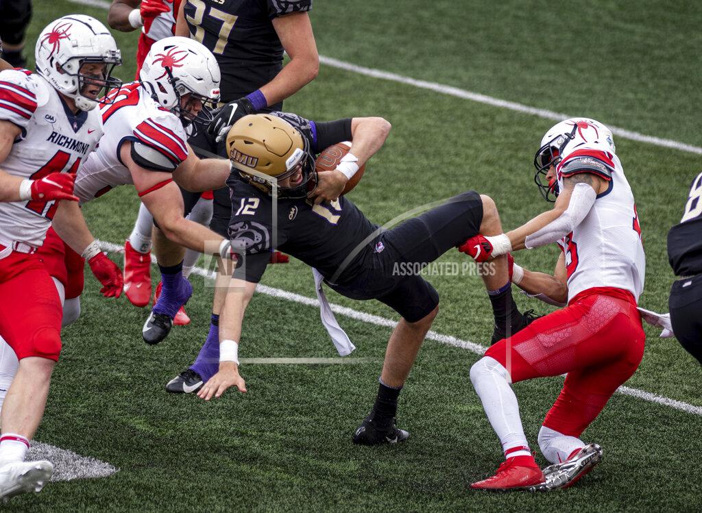 Daniel Lin James Madison quarterback Cole Johnson (12) tries to keep his balance as he threads his way through Richmond defense during the second half of an NCAA college football game in Harrisonburg, Va., Saturday, April 17, 2021. (Daniel Lin/Daily News-Record Via AP)