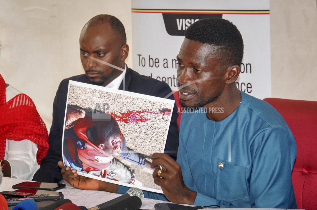 Ronald Kabuubi Ugandan opposition presidential candidate Bobi Wine shows a photograph depicting a victim of recent electoral-related violence in the country, at the Electoral Commission in Kampala, Uganda Wednesday, Dec. 2, 2020. Wine said Wednesday after meeting the head of the country's electoral body that he would resume his campaign after suspending it in protest over police brutality after police shot his car tires and fired rubber bullets that injured his bodyguards and supporters. (AP Photo/Ronald Kabuubi)