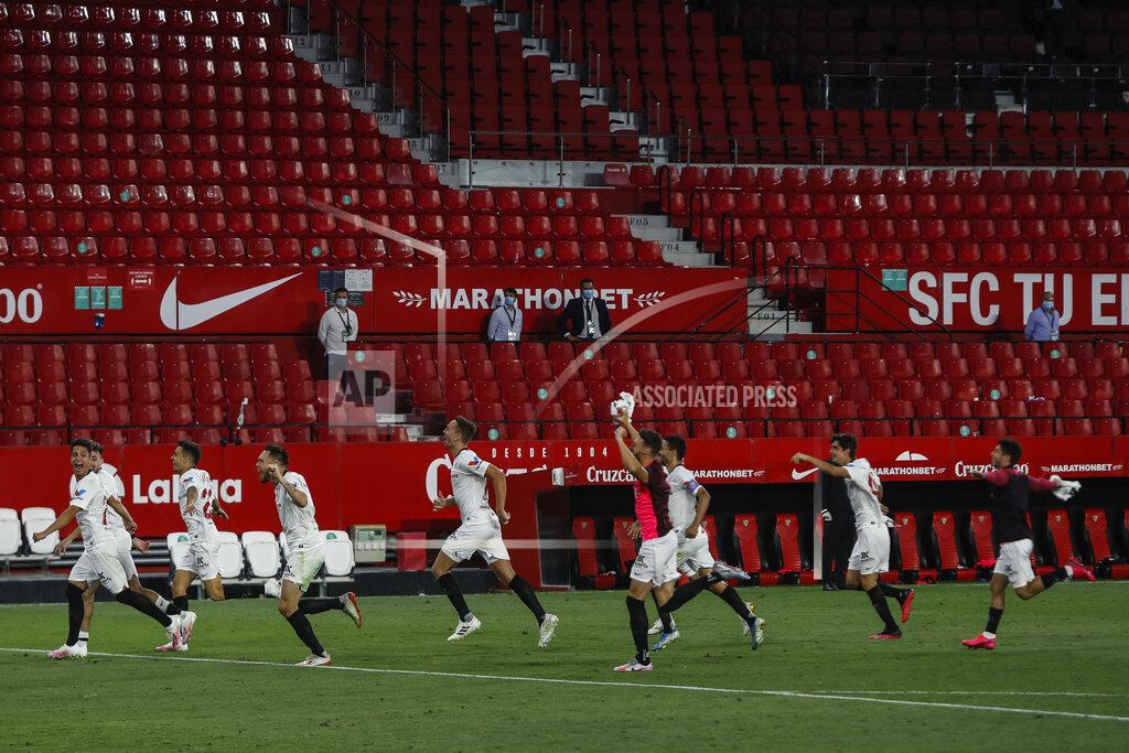 Str Sevilla players celebrate their Spanish La Liga soccer match victory against Betis in Seville, Spain, Thursday, June 11, 2020. With virtual crowds, daily matches and lots of testing for the coronavirus, soccer is coming back to Spain. The Spanish league resumes this week more than three months after it was suspended because of the pandemic, becoming the second top league to restart in Europe. The Bundesliga was first. The Premier League and the Italian league should be next in the coming weeks. (AP Photo)