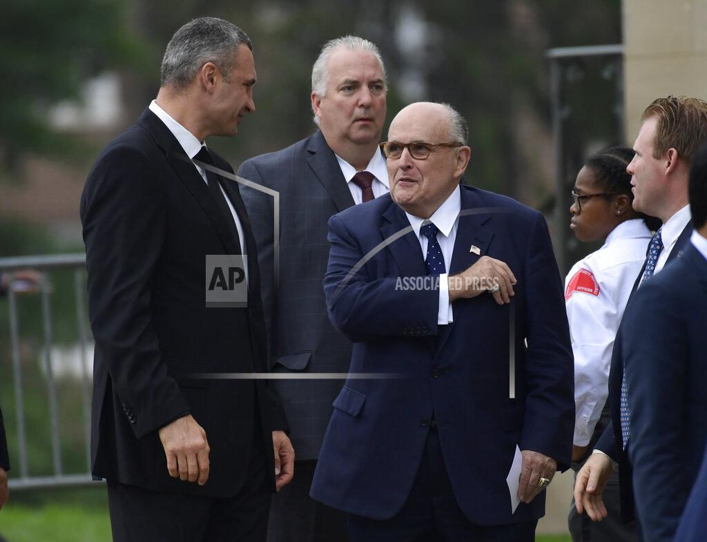 FILE - In this Saturday, Sept. 1, 2018 file photo, President Trump's attorney Rudy Giuliani, center, talks with Ukrainian boxing champ Wladimir Klitschko, left, as they arrive to attend a memorial service for Sen. John McCain, R-Ariz., at the Washington National Cathedral in Washington. Former heavyweight boxing champion turned philanthropist and management thinker Wladimir Klitschko praises his home country of Ukraine in a year when it has had a starring role in politics and on television in the United States. (AP Photo/Susan Walsh, File)