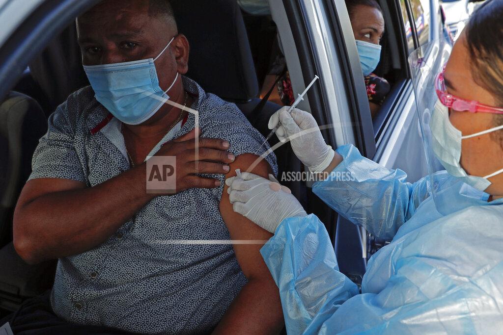 Arnulfo Franco A man gets a first shot of the AstraZeneca vaccine for COVID-19 in a car at the Rommel Fernandez soccer stadium where the parking lot is being used as a vaccination center in Panama City, Thursday, April 22, 2021. (AP Photo/Arnulfo Franco)