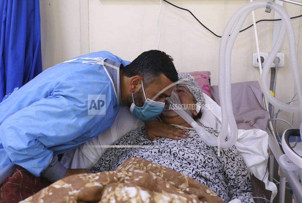 Rahmat Gul An Afghan man talks with his mother in the intensive care unit ward for COVID-19 patients at the Afghan-Japan Communicable Disease Hospital in Kabul, Afghanistan, Sunday, May 30, 2021. Afghanistan is battling a brutal third wave of COVID infections, while health officials plead for vaccines, expressing deep frustration at the inequities of the global vaccine distribution. Positive COVID cases jump from eight percent to 60 per cent in some parts of the country. (AP Photo/Rahmat Gul)