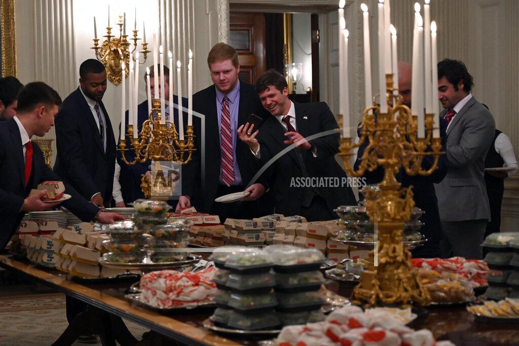 Susan Walsh Guests attending a reception for the Clemson Tigers grab fast food sandwiches in the State Dining Room of the White House in Washington, Monday, Jan. 14, 2019. (AP Photo/Susan Walsh)