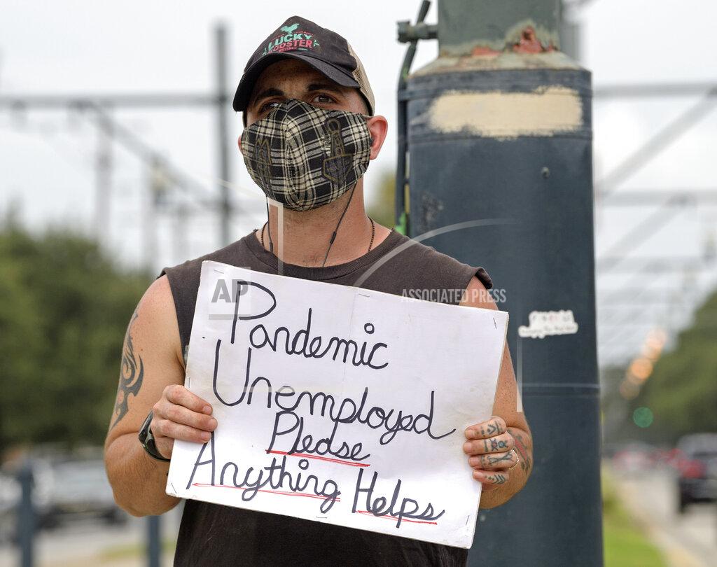 Staff Photo By Max Becherer Sean Harris holds a sign asking for help while standing on the neutral ground on Carrollton Ave. at Bienville Ave. in New Orleans, Friday, Sept. 4, 2020. Harris had just completed training to be a hunted history tour guide in the French Quarter when the coronavirus pandemic hit. He has not been able to find a job since. (Max Becherer/The Times-Picayune/The New Orleans Advocate via AP)