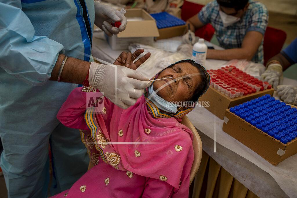 Altaf Qadri A health worker takes a nasal swab sample of a passenger to test for COVID-19 at a bus terminal in New Delhi, India, Wednesday, March 24, 2021. (AP Photo/Altaf Qadri)