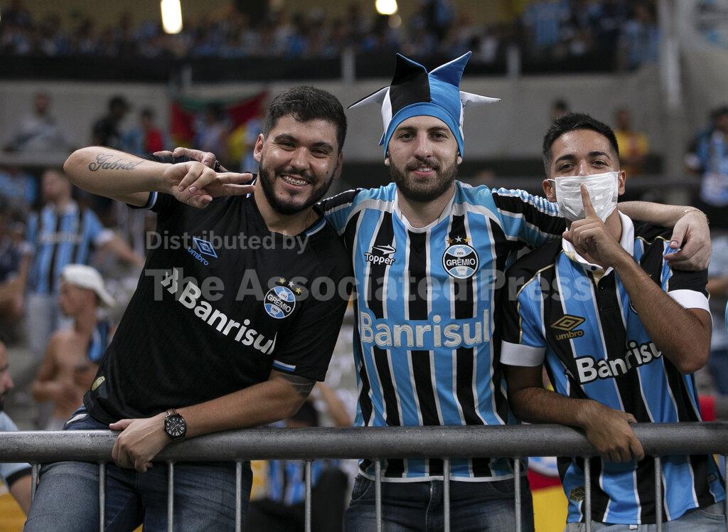 Fans of Brazil's Gremio pose for a photo prior to a Copa Libertadores soccer match against Internacional at Gremio Arena in Porto Alegre, Brazil, Thursday, March 12, 2020. (AP Photo/Liamara Polli)