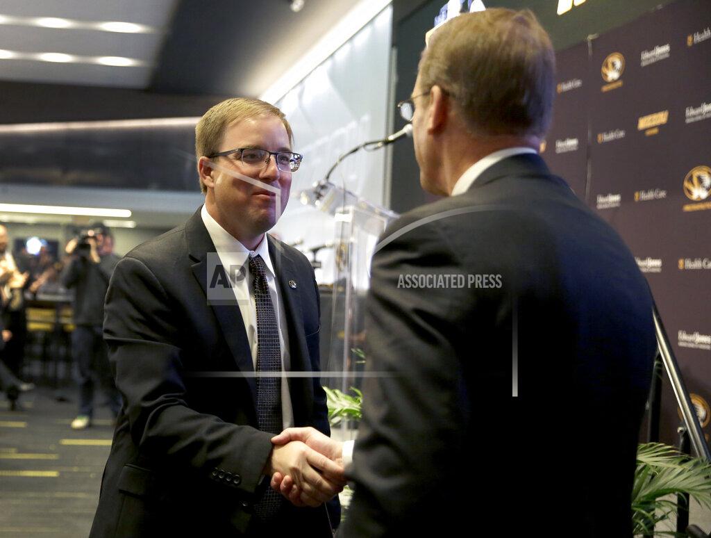 Jeff Roberson Eliah Drinkwitz, left, stops to shake hands with Mizzou Director of Athletics Jim Sterk as Drinkwitz heads to the stage to be introduced as the new NCAA college football head coach at the University of Missouri, Tuesday, Dec. 10, 2019, in Columbia, Mo. Drinkwitz becomes the 33rd head football coach at Missouri after coaching the 2019 season at Appalachian State. (AP Photo/Jeff Roberson)