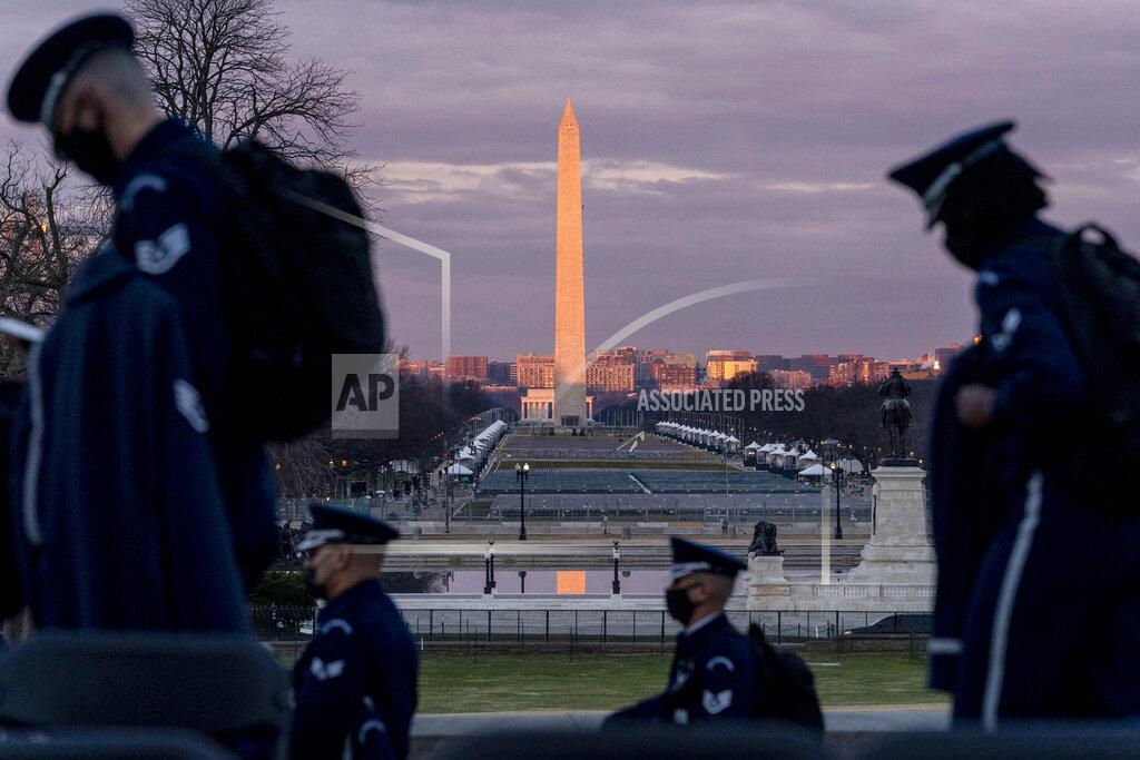 Andrew Harnik The Washington Monument and the National Mall are visible as members of the U.S. Air Force Honor Guard walk along the West Front of the U.S. Capitol at the site of the 59th Presidential Inauguration in Washington, Monday, Jan. 18, 2021. (AP Photo/Andrew Harnik)