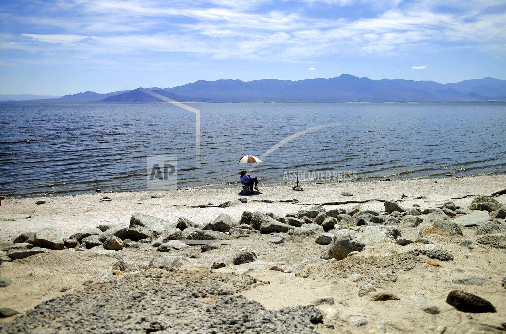 Gregory Bull FILE - In this April 30, 2015, file photo, a man fishes for tilapia along the receding banks of the Salton Sea near Bombay Beach, Calif. Two major California water agencies have settled a lawsuit that once threatened to derail a multi-state agreement to protect a river that serves millions of people in the U.S. West. The agencies announced Monday, Sept. 20, 2021, they have reached a settlement that resolves both lawsuits. (AP Photo/Gregory Bull, File)