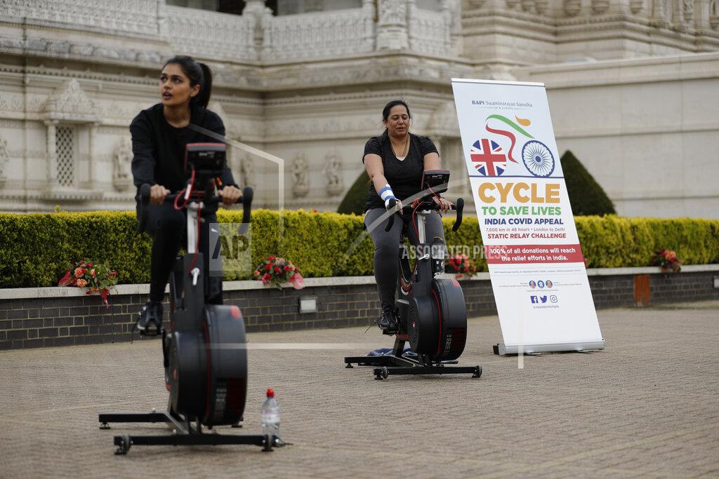 People take part in "Cycle to Save Lives" a 48 hour, non-stop static relay cycle challenge at the BAPS Shri Swaminarayan Mandir, also know as the Neasden Temple, the largest Hindu temple in the UK, in north London, to raise money to help coronavirus relief efforts in India, Saturday, May 1, 2021. The challenge sees people combining at three different venues in the UK, cycling in a static relay the equivalent distance of 7,600 Km, which is the distance from London to Delhi. (AP Photo/Matt Dunham)