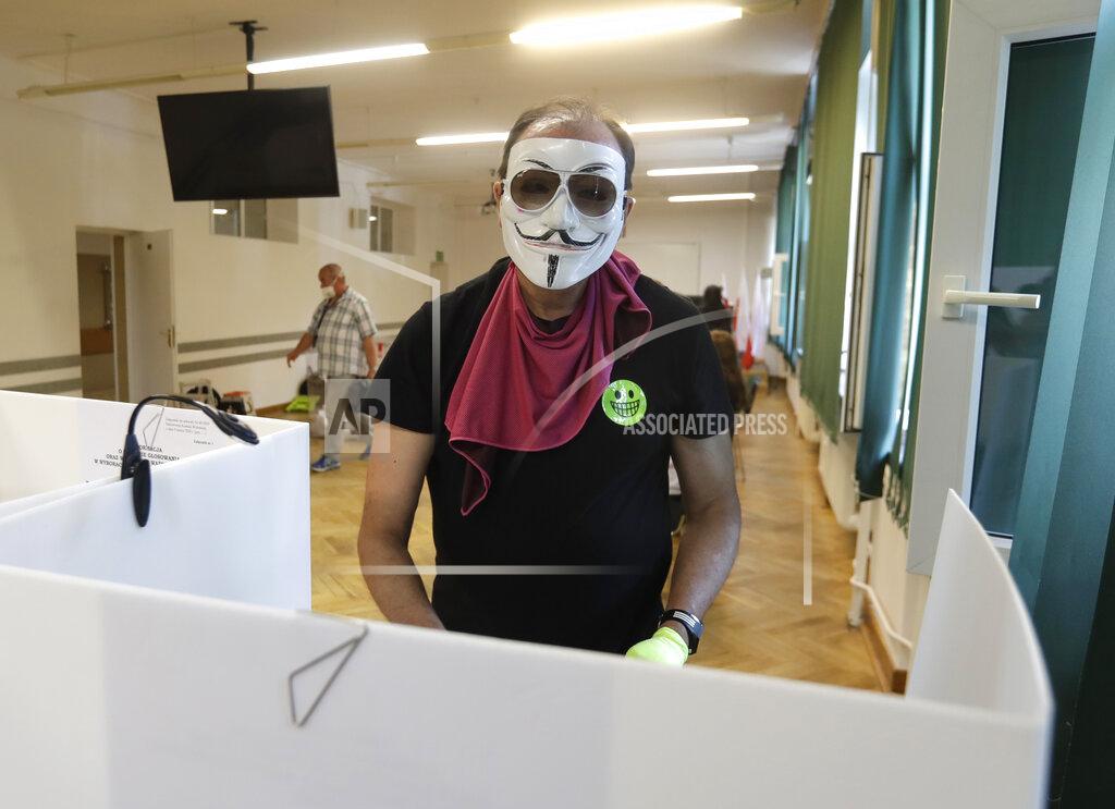 Petr David Josek A man, wearing a face mask, prepares to cast his vote during presidential election in Warsaw, Poland, Sunday, June 28, 2020. The election will test the popularity of incumbent President Andrzej Duda who is seeking a second term and of the conservative ruling party that backs him. (AP Photo/Petr David Josek)