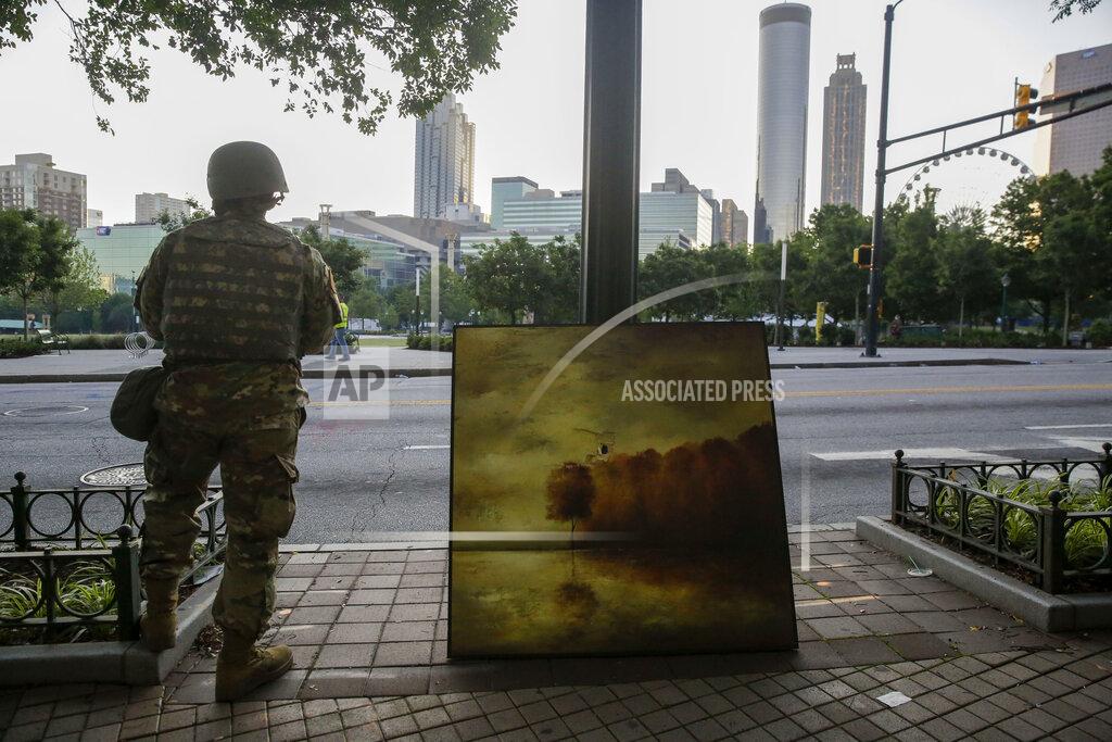 Brynn Anderson A member of National Guard stands near a painting that was damaged in the aftermath of a demonstration against police violence on Saturday, May 30, 2020, in Atlanta. (AP Photo/Brynn Anderson)