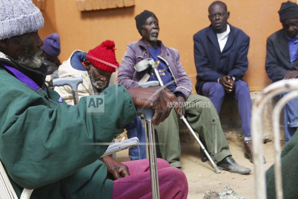 Tsvangirayi Mukwazhi Elderly men wait to be served a meal at Melfort Old People's home on the outskirts of Harare, Zimbabwe, Sunday, July 25, 2021. The economic ravages of COVID-19 are forcing some families in Zimbabwe to abandon the age old tradition of taking care of the elderly. Zimbabwe's care homes have experienced a 60% increase in admissions since the outbreak of the pandemic in March last year. (AP Photo/Tsvangirayi Mukwazhi)