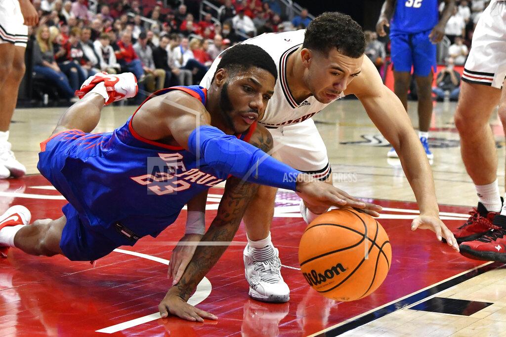Timothy D. Easley DePaul guard Courvoisier McCauley (23) and Louisville guard Jarrod West (13) reach for the ball during the first half of an NCAA college basketball game in Louisville, Ky., Friday, Dec. 10, 2021. (AP Photo/Timothy D. Easley)
