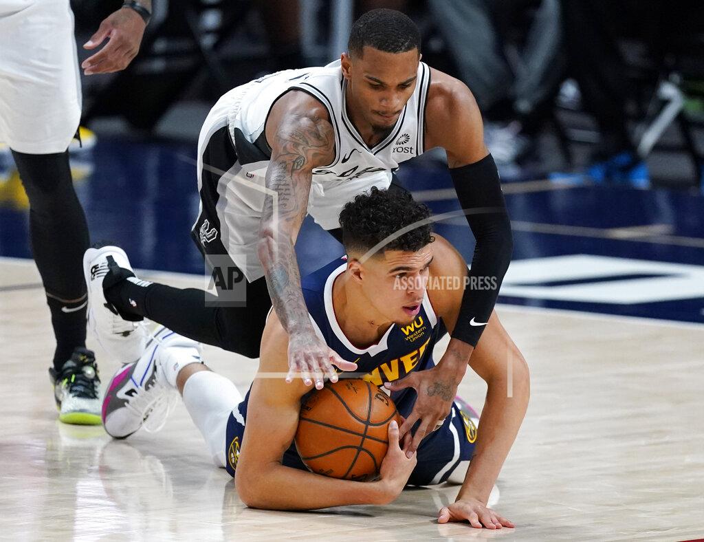 David Zalubowski Denver Nuggets forward Michael Porter Jr., bottom, cover the ball as San Antonio Spurs guard Dejounte Murray defends in the first half of an NBA basketball game Friday, April 9, 2021, in Denver. (AP Photo/David Zalubowski)