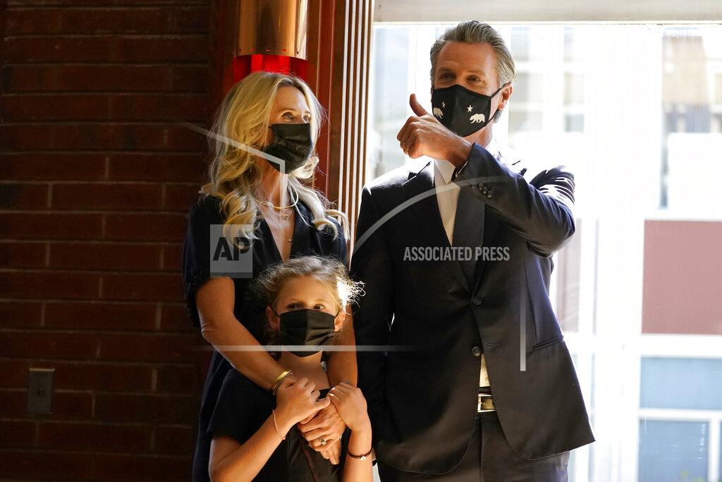Jeff Chiu Gov. Gavin Newsom, right, gestures next to his wife, first partner Jennifer Siebel Newsom, and their daughter, Brooklynn, before speaking to volunteers in San Francisco, Tuesday, Sept. 14, 2021. The recall election that could remove California Democratic Gov. Newsom is coming to an end. Voting concludes Tuesday in the rare, late-summer election that has emerged as a national battlefront on issues from COVID-19 restrictions to climate change. (AP Photo/Jeff Chiu)