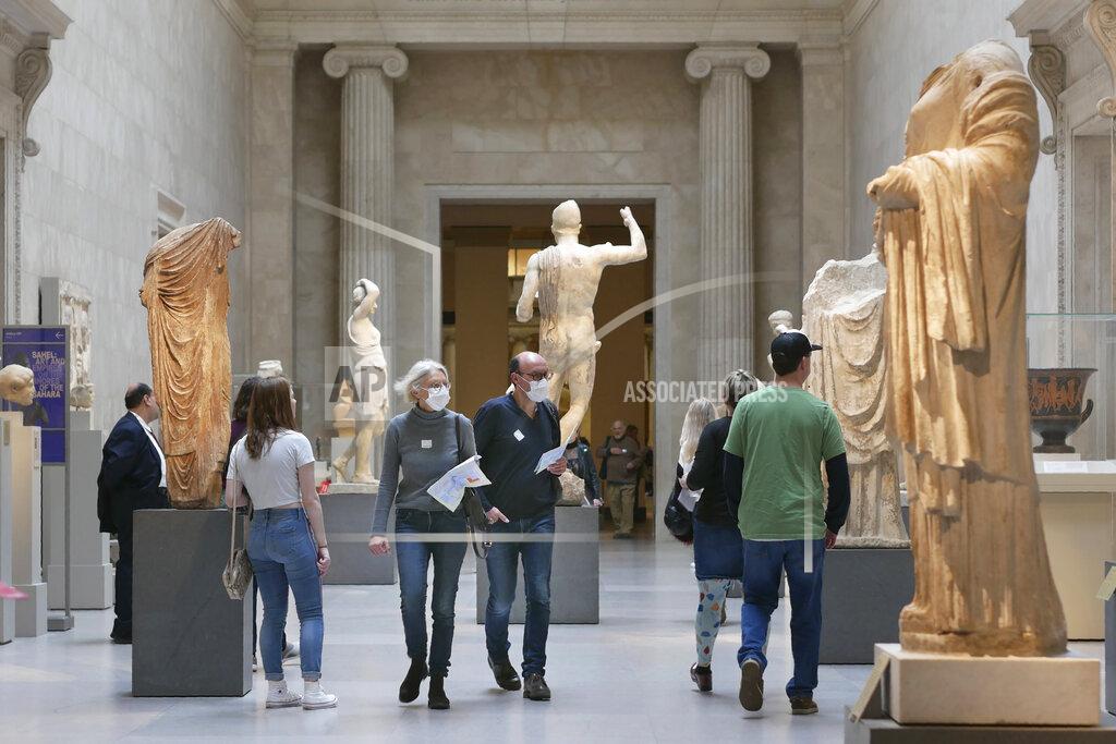 FILE - In this Tuesday, March 10, 2020 file photo, two visitors wear masks as they walk through the Metropolitan Museum of Art in New York. New York City won't open malls and museums Monday, July 20, 2020, even if the city is allowed to move into the next phase of reopening, as Gov. Andrew Cuomo promises more crackdowns on bars and restaurants. Of the Metropolitan Museum: "I think they can plan to reopen. And then we'll see what the facts say," Cuomo said. (AP Photo/Seth Wenig, File)