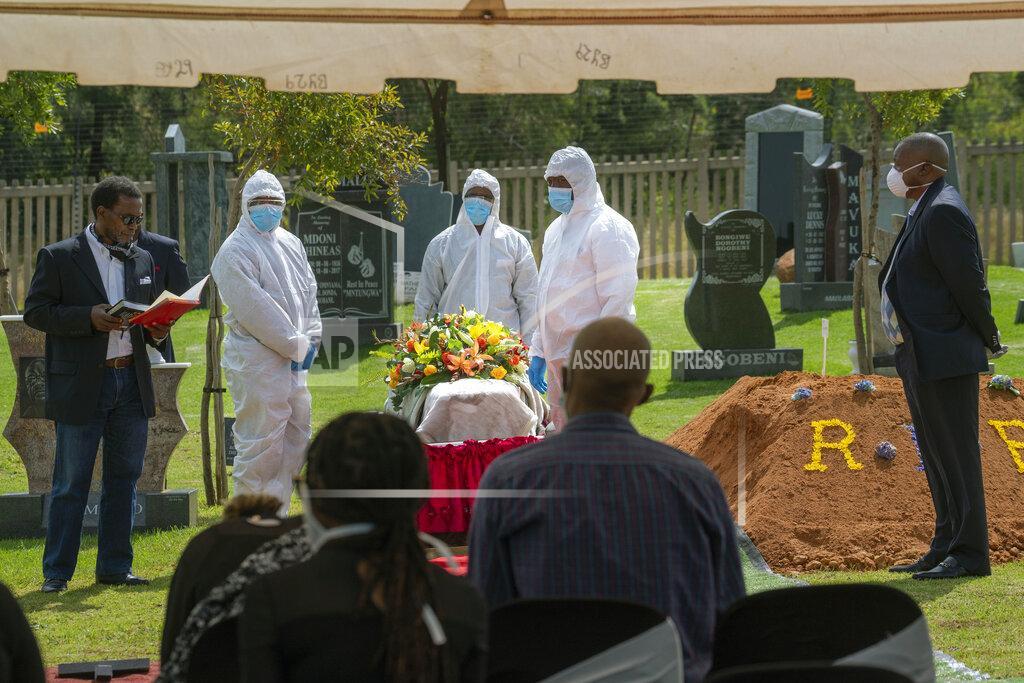 Jerome Delay Family and friends listen to the eulogy for Benedict Somi Vilakasi at his burial ceremony at the Nasrec Memorial Park outside Johannesburg Thursday, April 16, 2020. Vilakasi, a Soweto coffee shop manager, died of Covid-19 infection in a Johannesburg hospital Sunday April 12 2020. South Africa is under a strict five-week lockdown in a effort to fight the Coronavirus pandemic.(AP Photo/Jerome Delay)