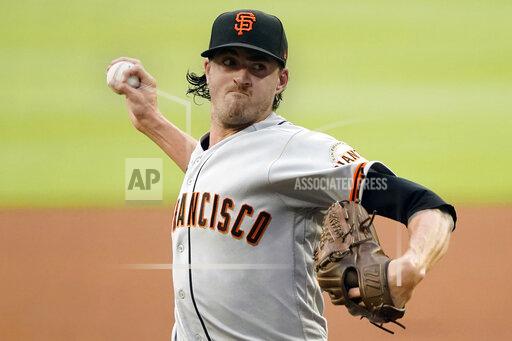 FILE -San Francisco Giants stating pitcher Kevin Gausman works against the Atlanta Braves during the first inning of a baseball game Friday, Aug. 27, 2021, in Atlanta. The Toronto Blue Jays have reached an agreement with right-hander Kevin Gausman on a five-year, $110 million contract, pending a physical, a person familiar with the deal told The Associated Press late Sunday, Nov. 28, 2021. (AP Photo/John Bazemore, File)