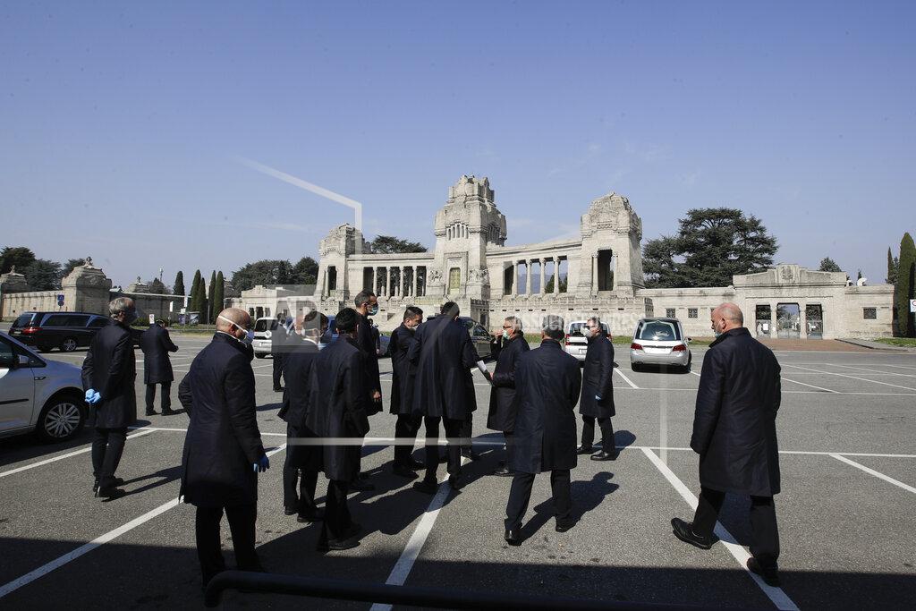 Luca Bruno FILE - In this Tuesday, March 17, 2020 file photo, pallbearers stand outside the Monumentale cemetery, in Bergamo, the heart of the hardest-hit province in Italy's hardest-hit region of Lombardy, Italy. Italy is poised to reclaim the dishonor of reporting the most coronavirus deaths in Europe, as the second surge ravages the country’s disproportionately old population and exposes how public health shortfalls and delayed restrictions compounded a lack of preparedness going into the pandemic. (AP Photo/Luca Bruno, File)
