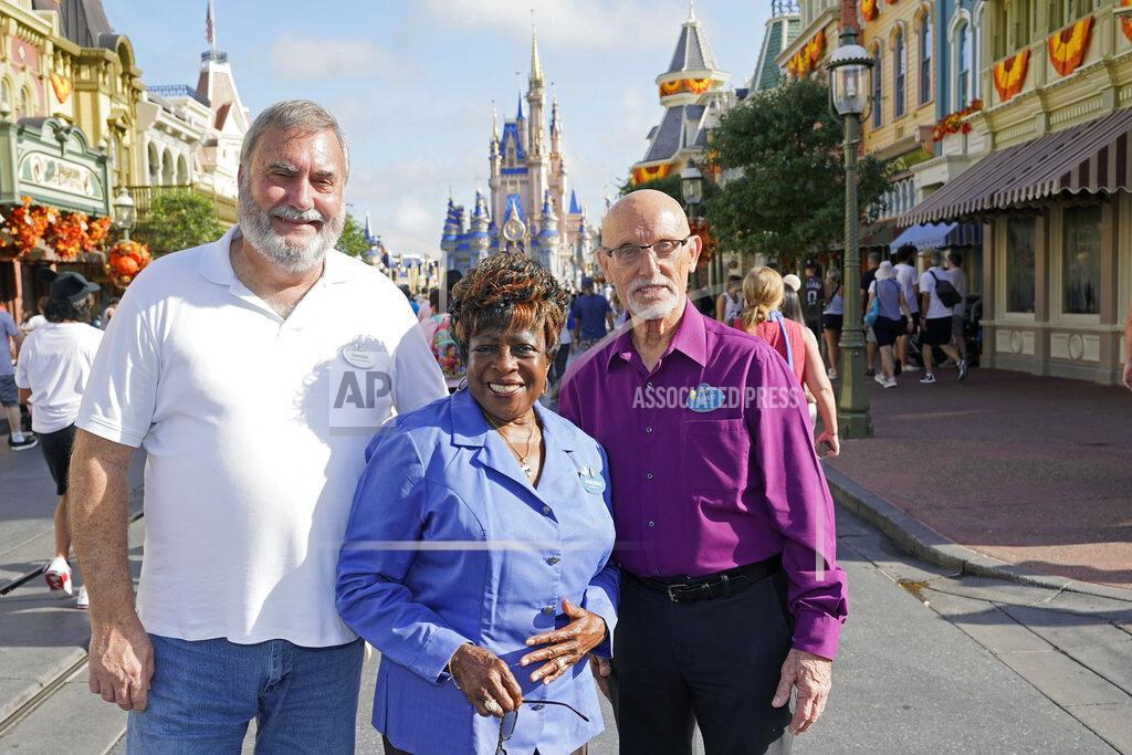 John Raoux Walt Disney World employees from left, Chuck Milam, Earliene Anderson and Forrest Bahruth gather at the Magic Kingdom Monday, Aug. 30, 2021, in Lake Buena Vista, Fla. to celebrate their 50 years working at the park. (AP Photo/John Raoux)