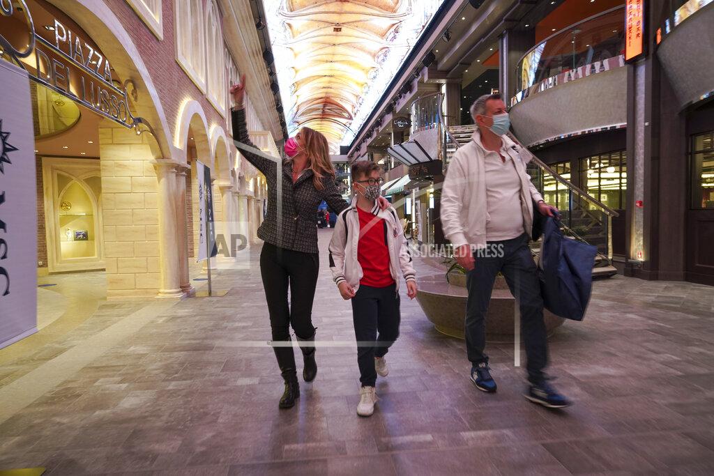 Andrew Medichini Passengers, Ilaria Gelli, 48, left, Federico Marzocchi, 45, right, and and their son Matteo Marzocchi, 10, walk on board the MSC Grandiosa cruise ship in Civitavecchia, near Rome, Wednesday, March 31, 2021. MSC Grandiosa, the world's only cruise ship to be operating at the moment, left from Genoa on March 30 and stopped in Civitavecchia near Rome to pick up more passengers and then sail toward Naples, Cagliari, and Malta to be back in Genoa on April 6. For most of the winter, the MSC Grandiosa has been a lonely flag-bearer of the global cruise industry stalled by the pandemic, plying the Mediterranean Sea with seven-night cruises along Italy’s western coast, its major islands and a stop in Malta. (AP Photo/Andrew Medichini)